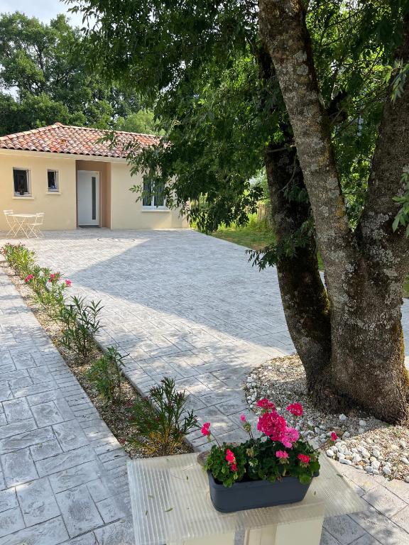 a house with a tree and flowers in a courtyard at Maison d'hôtes à Castres-Saïx in Saix