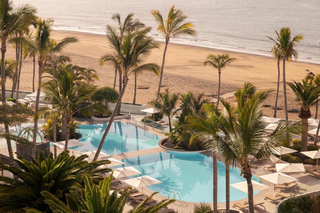 an aerial view of a resort with palm trees and a beach at Plus Fariones Suite Hotel in Puerto del Carmen