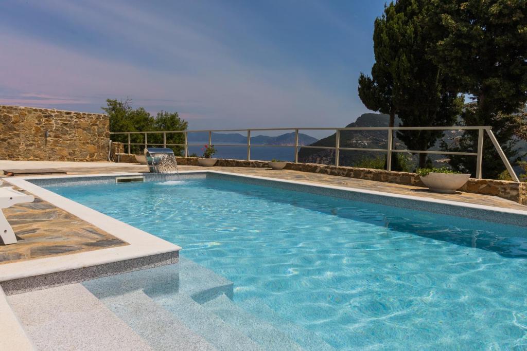 a swimming pool with blue water in a house at Villa Mirage Skopelos in Skopelos Town