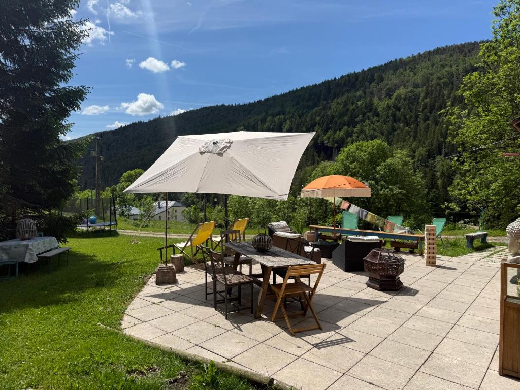 a patio with a table and an umbrella at Dharma Farm Retreat in Mijoux