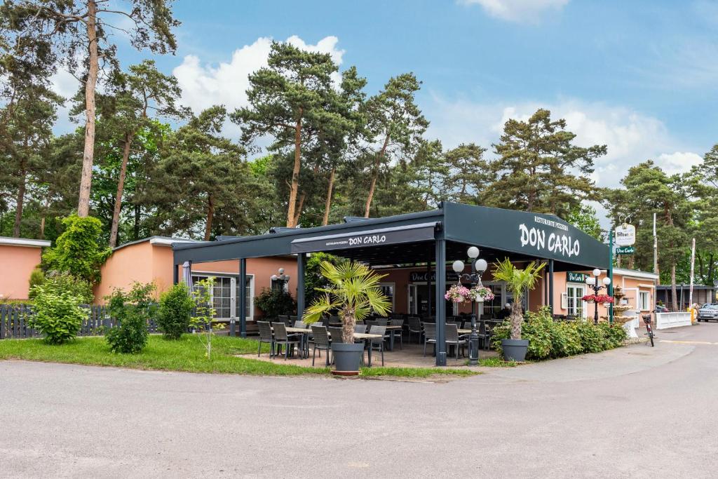 a building with a restaurant with tables and plants at La Pura Vida - Glamping in Brandenburg an der Havel