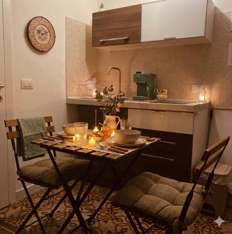 a kitchen with a table and two chairs and a sink at YOUR HOME 26 in Bari
