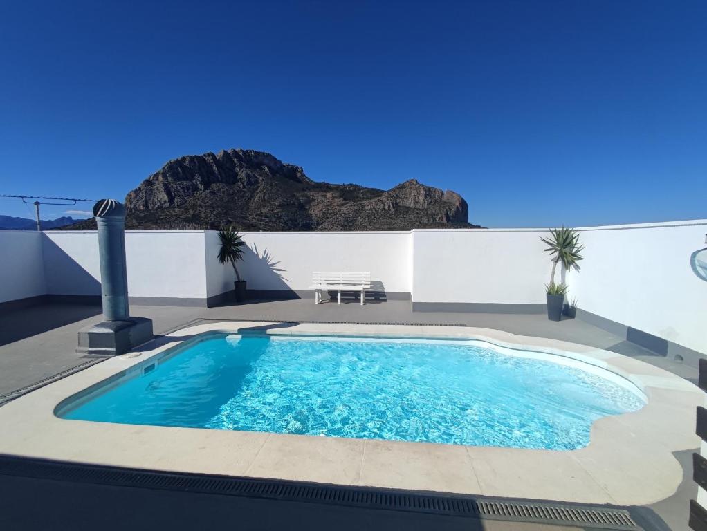 a swimming pool on the roof of a house with mountains in the background at Apartamento rodeado de mar y montañ in El Verger