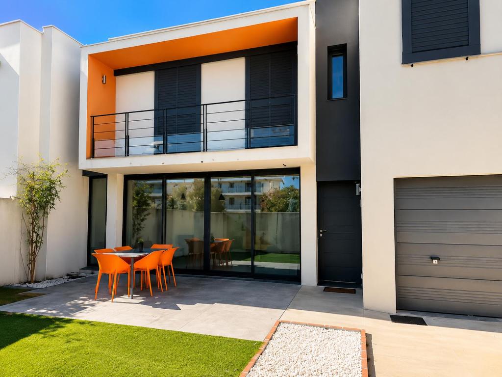 a house with orange chairs and a table in front of it at Sea Road Perpignan in Perpignan