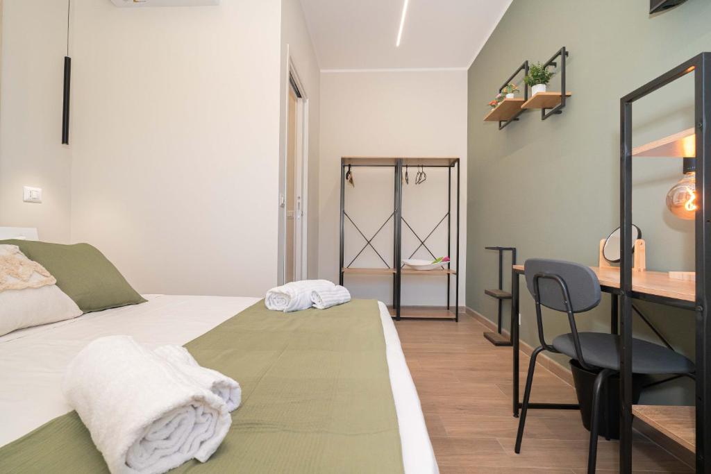 a bedroom with a bed and a desk and a chair at VJ Apartment in Giardini Naxos