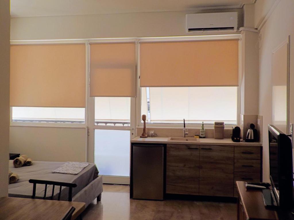 a kitchen with two large windows and a sink at GAIA City Studio in Kato Achaia