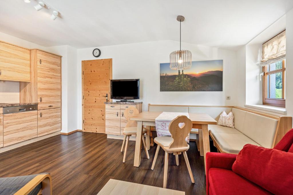 a kitchen and living room with a table and a couch at Appartements Stockinger B4 in Grossarl