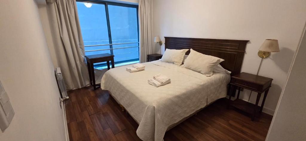 a bedroom with a bed with two towels on it at Millennium Mendoza pleno Centro 2 dormitorios, cocina completa, pileta y terraza in Mendoza