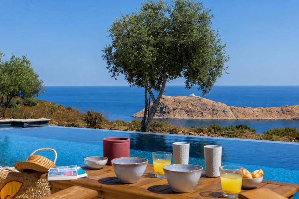 a wooden table with food on it next to a pool at Villa Bianca in LʼÎle-Rousse