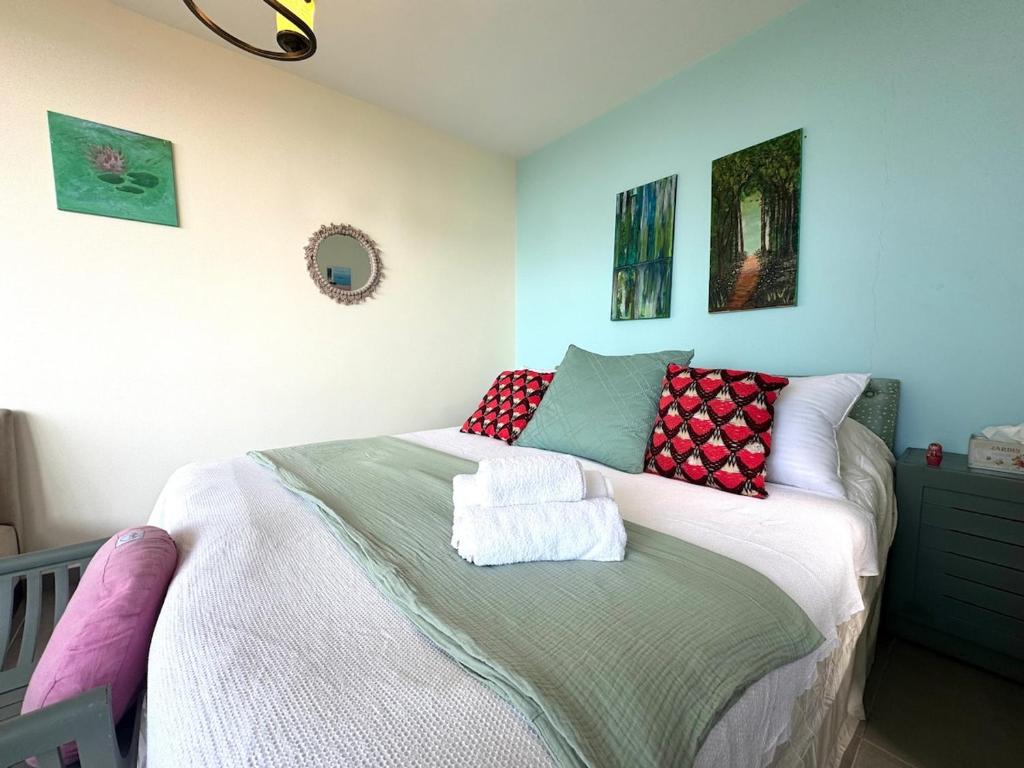 a bedroom with a bed with red and green pillows at Shakti, Abdelli guesthouse in Batroûn