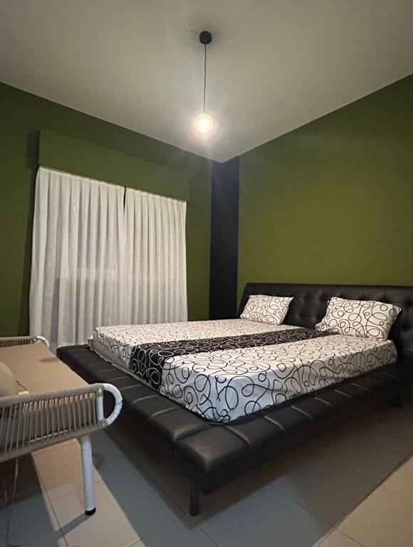a bed in a room with a black leather couch at Havenstay in Yaoundé