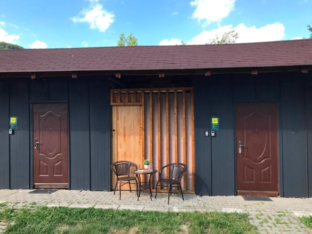 a patio with chairs and a table in front of a building at Chalmová CHATA 27 in Bystričany