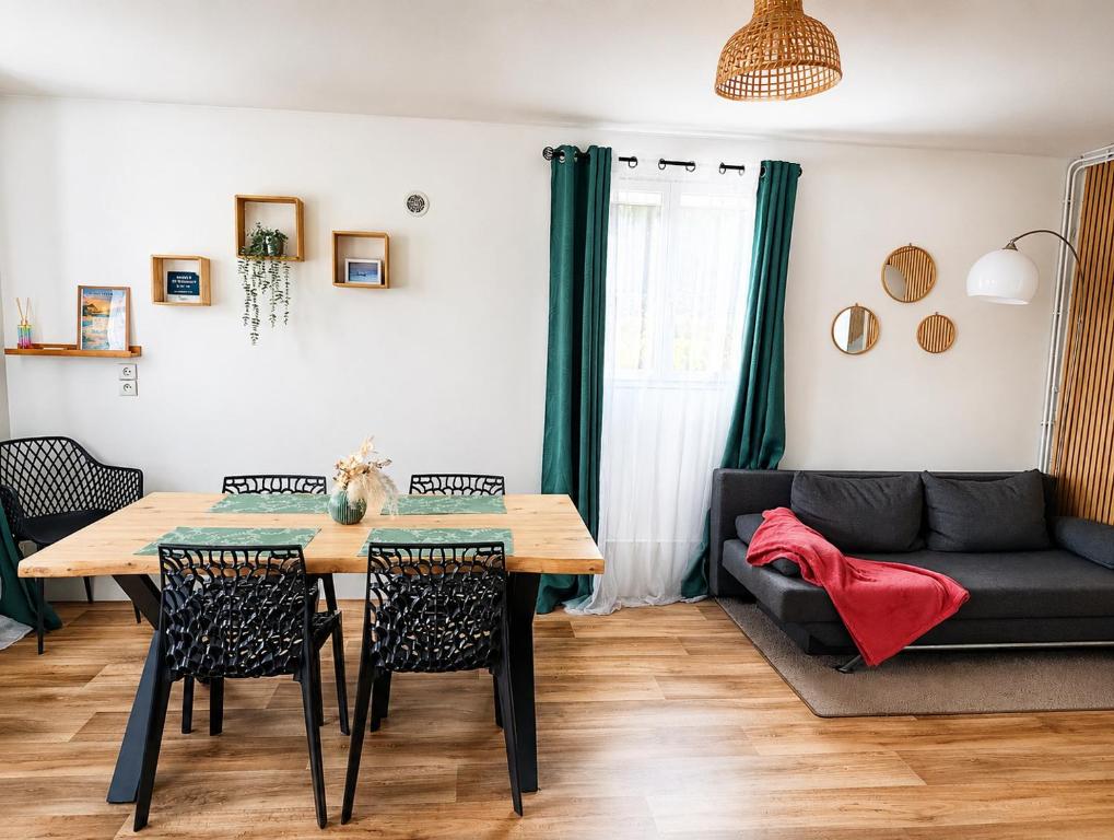 a living room with a table and a couch at Le petit paradis in Abbeville