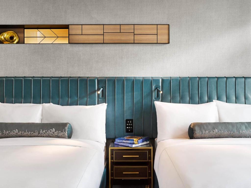 two beds sitting next to each other in a room at Fairmont Quasar Istanbul Hotel in Istanbul
