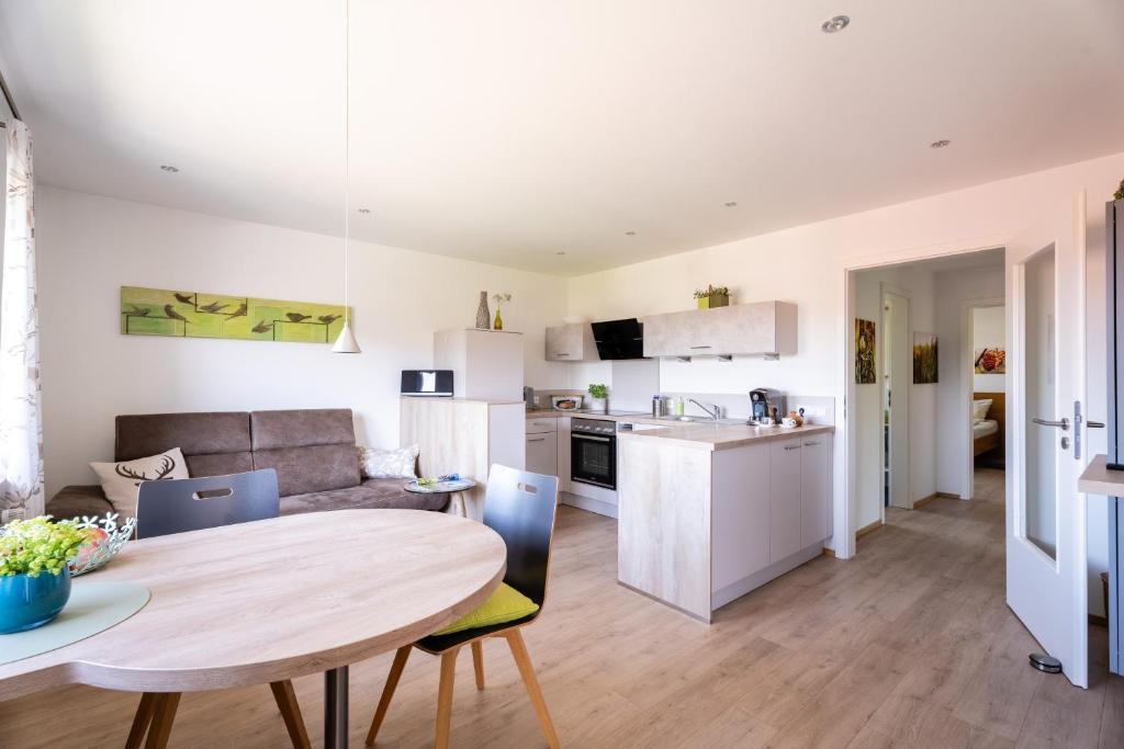a kitchen and a living room with a table and chairs at Hofquartier in Kappelrodeck