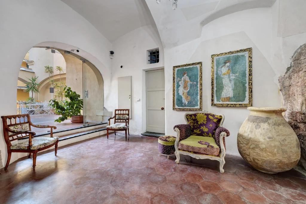 a room with chairs and a large vase on the wall at Al Castello Residenza D'Epoca in Pietra Ligure
