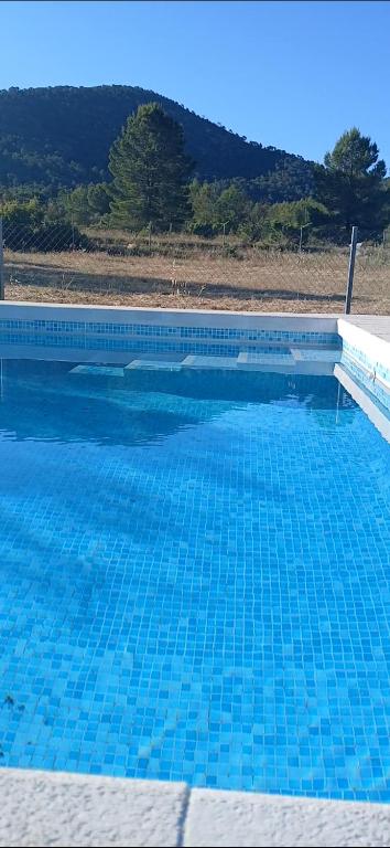 a large blue swimming pool with blue water at Casa la Serrana in Yecla