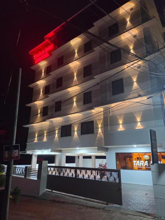 a tall building with lights on it at night at Tara inn in Alwaye