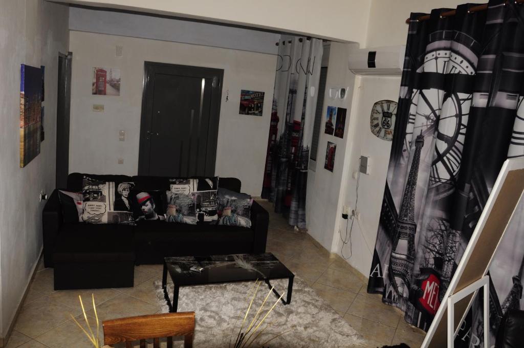 イラクリオン・タウンにあるIonias Apartmentのリビングルーム(黒いソファ、テーブル付)