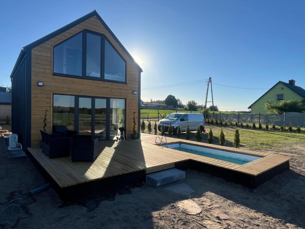 a house with a deck and a swimming pool at Perła prosto z Borów in Cekcyn