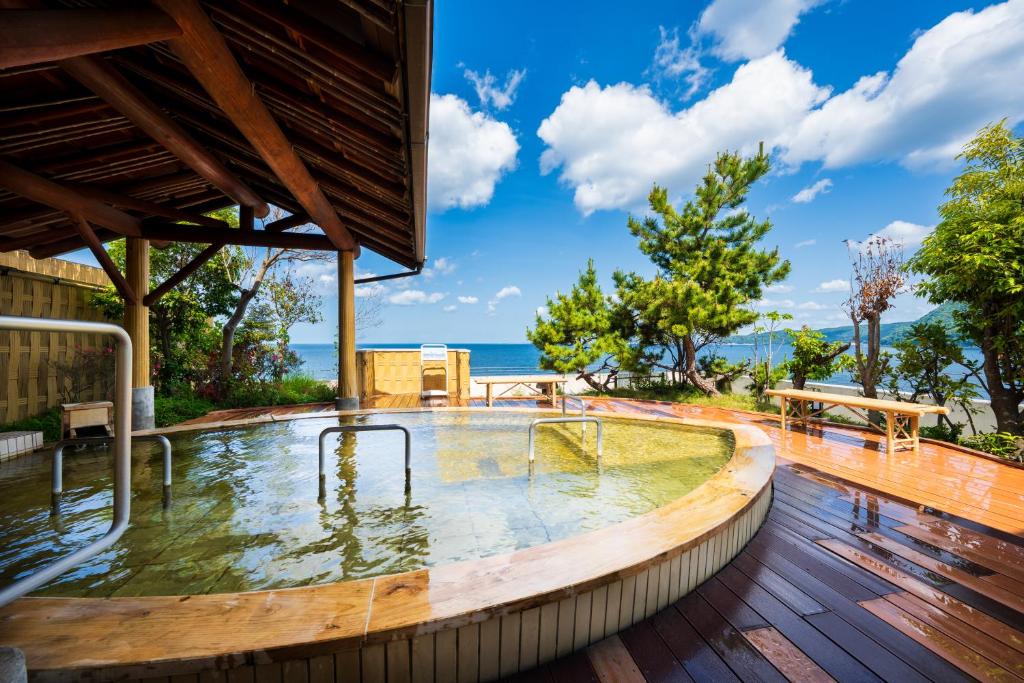 a hot tub on the deck of a house at Seaside Hotel Mimatsu Ooetei in Beppu