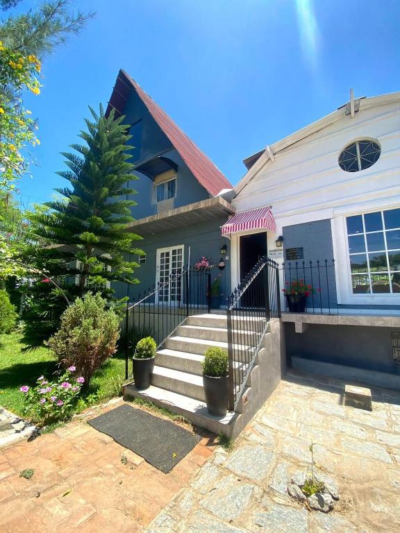 a blue house with a porch and stairs at Pousada Sítio Bosque in Campina Grande