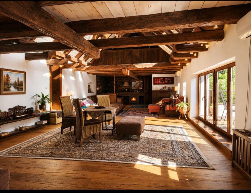 a living room with wooden ceilings and a table and chairs at Zalanka in Zalaköveskút