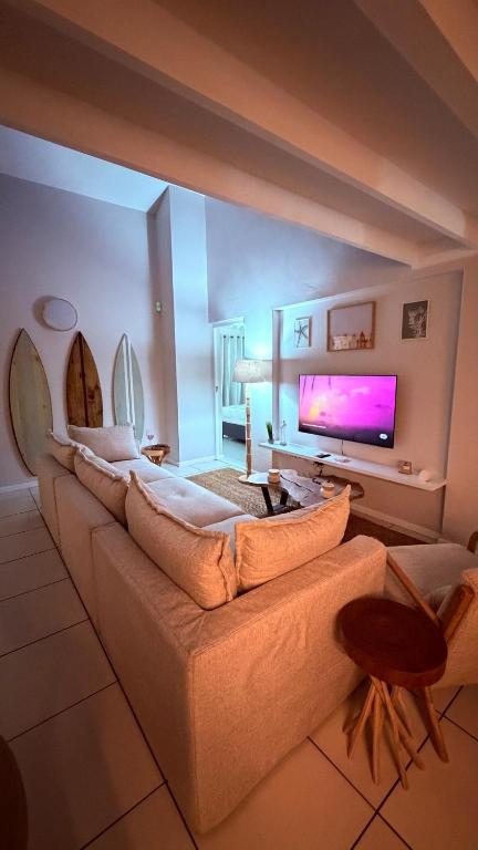 a living room with a couch and a flat screen tv at Sunset Beach Self-Catering in Marina da Gama
