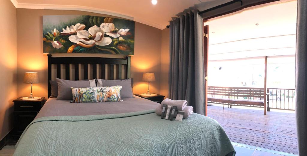 a bedroom with a bed with a painting on the wall at Golf View Lodge Melmoth in Melmoth