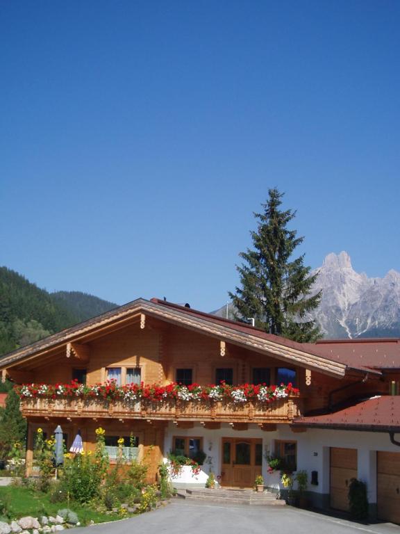 a building with red flowers on the roof at Zur lieben Sonne in Filzmoos
