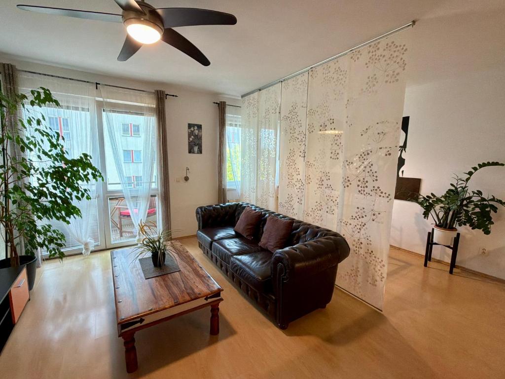 a living room with a leather couch and a table at Richie Apartment near Aquapark in Prague