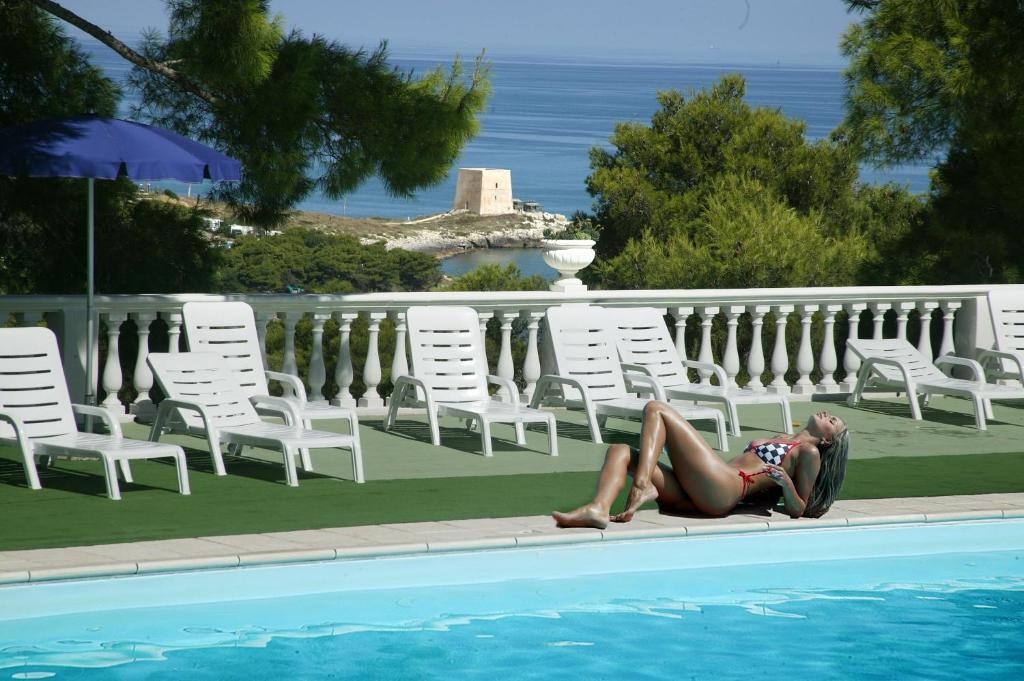 une femme se posant sur le côté d'une piscine dans l'établissement Residence Emarine, à Peschici