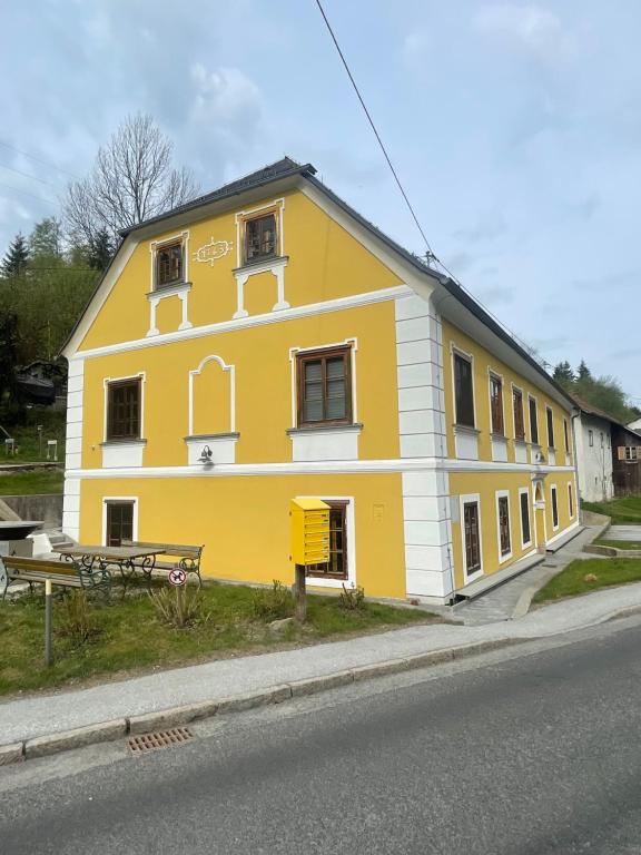 a yellow and white building on the side of a street at Ferienwohnung Raabklamm in Arzberg