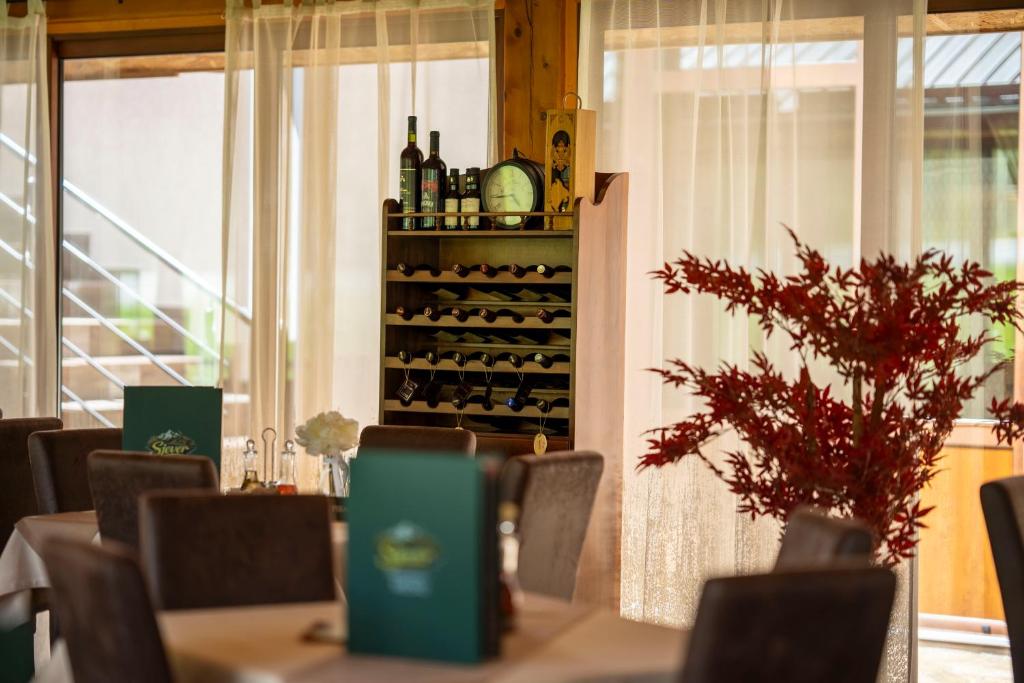 a dining room with a table with bottles of wine at Hotel Sjever in Šavnik