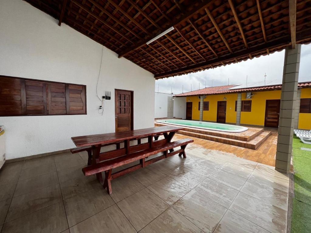 a wooden bench in a room with a pool at Lotus Beach in Piaçabuçu