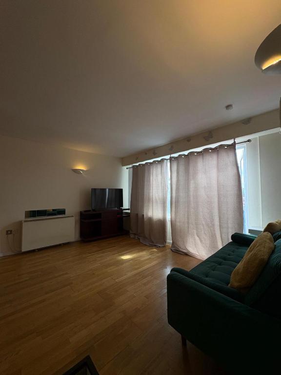 a living room with a couch and a large window at Beautiful 2 Bedroom - Woolwich in Woolwich