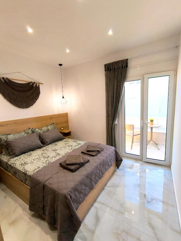 a bedroom with a large bed and a balcony at Anthouli homes 4, steps from beach and centre in Kardamaina