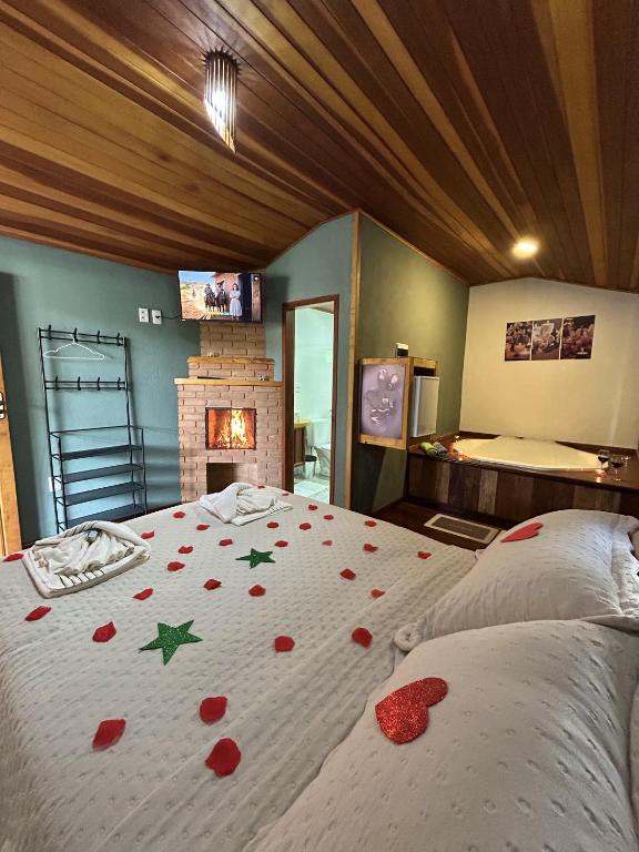 a bedroom with a bed with red rose petals on it at Chalé samambaia in Resende