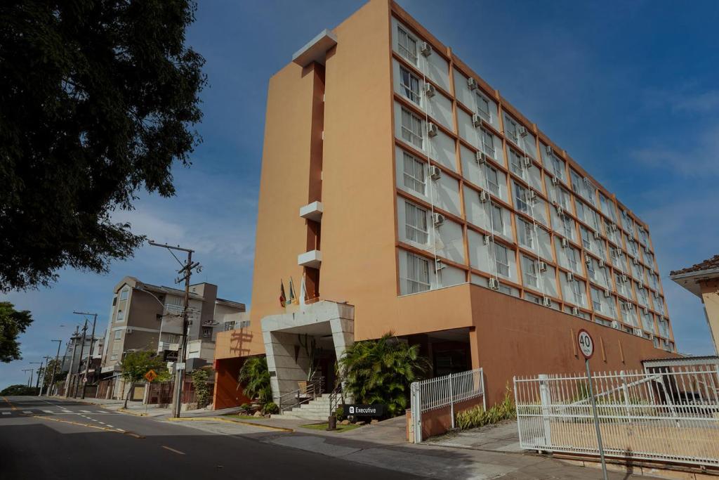 a hotel on a city street with a building at Tri Hotel Executive Santa Maria in Santa Maria