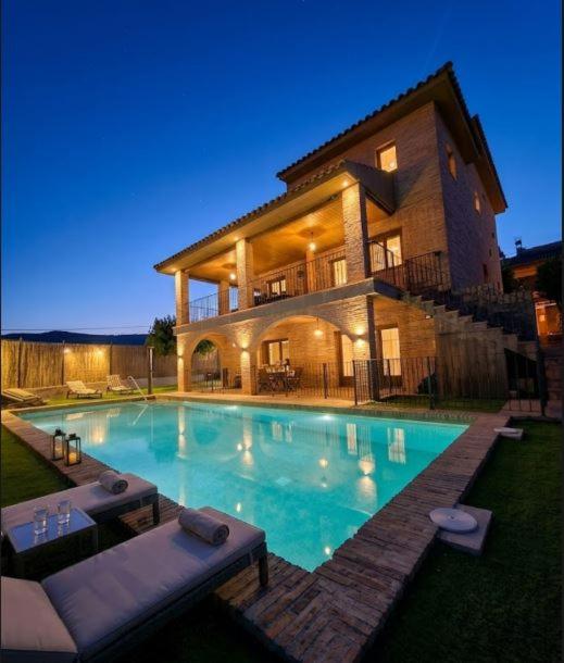 a large swimming pool in front of a house at MEQUEDO el ESPOLON in Alcañiz