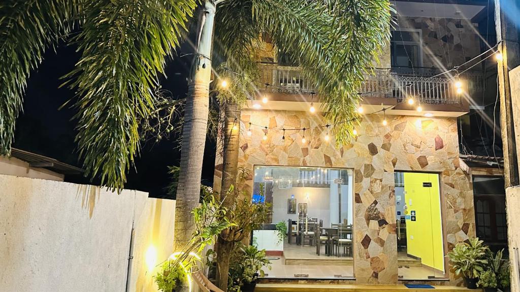 a house with a yellow door and palm trees at New Rani Inn in Negombo
