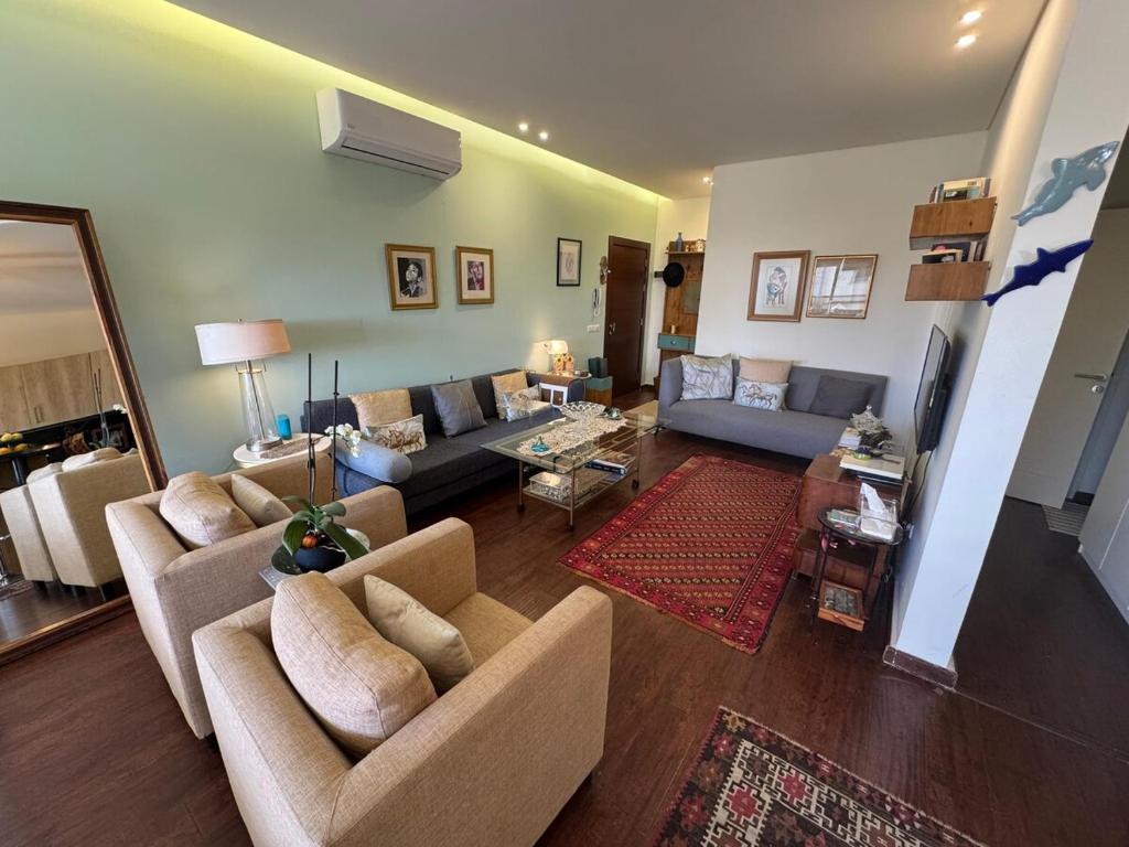 a living room with two couches and a table at Batroun Escape, 2BR, 24-7 elect, beach view! in Batroûn