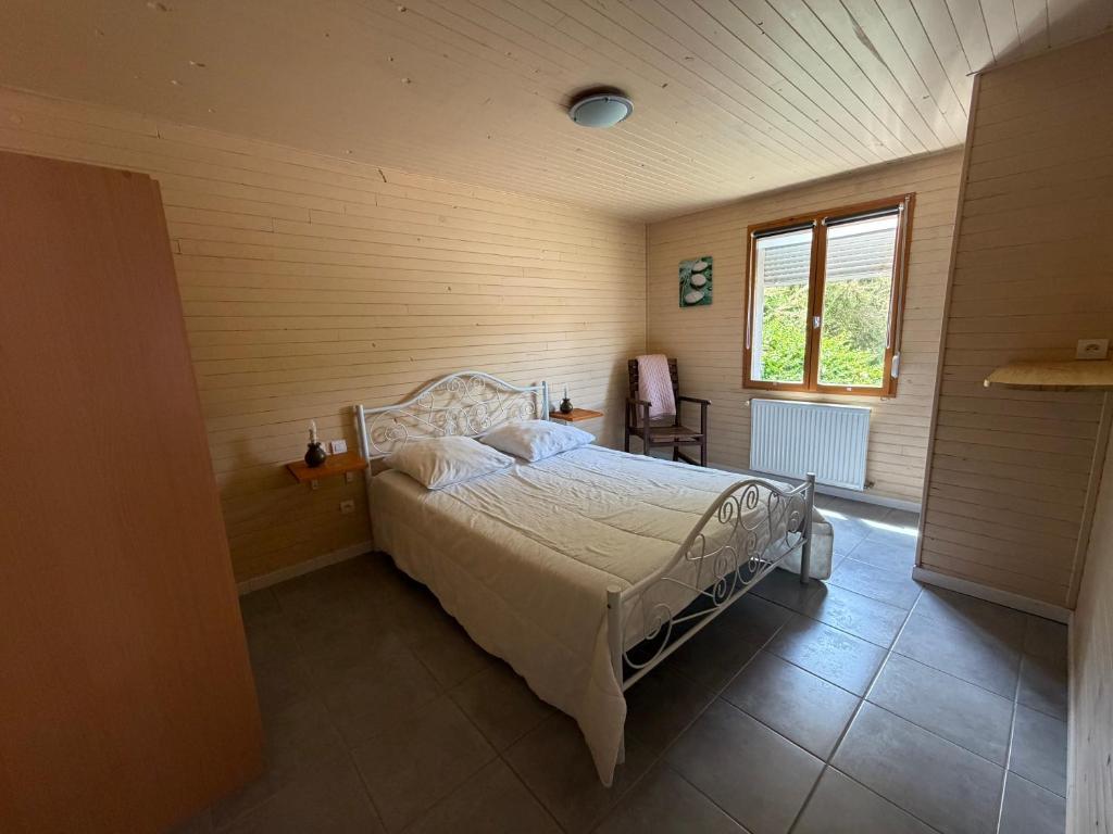 a bedroom with a bed in a room with a window at Le chant des oiseaux chambre pour quatre à quelques minutes de la Baie de Somme entre nature mer et télétravail in Nibas
