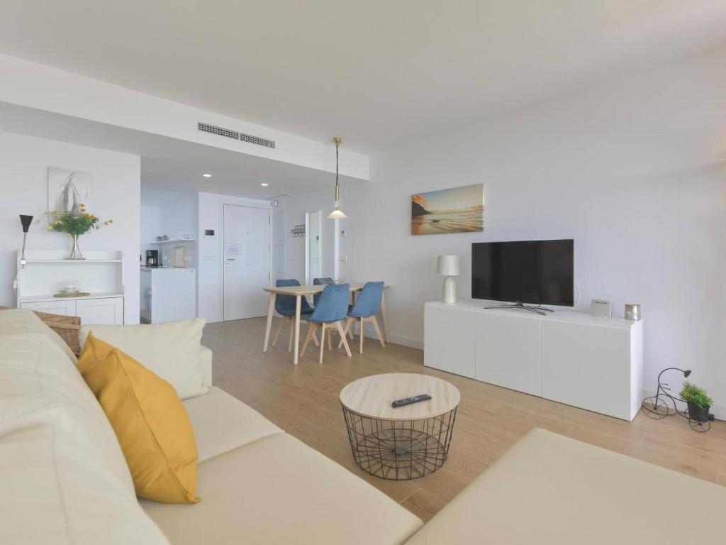 a living room with a white couch and a tv at Apartamento de lujo vista mar en Torrox Costa in Torrox Costa