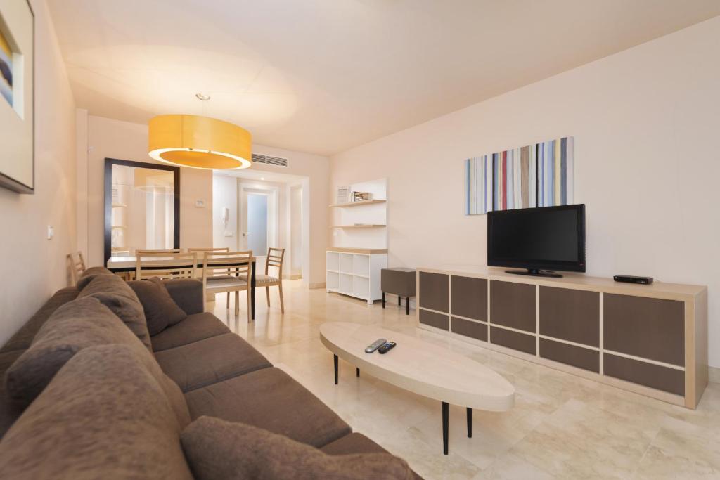 a living room with a couch and a dining room at Spacious 3 bedrooms apartment side sea view in Torrox Costa