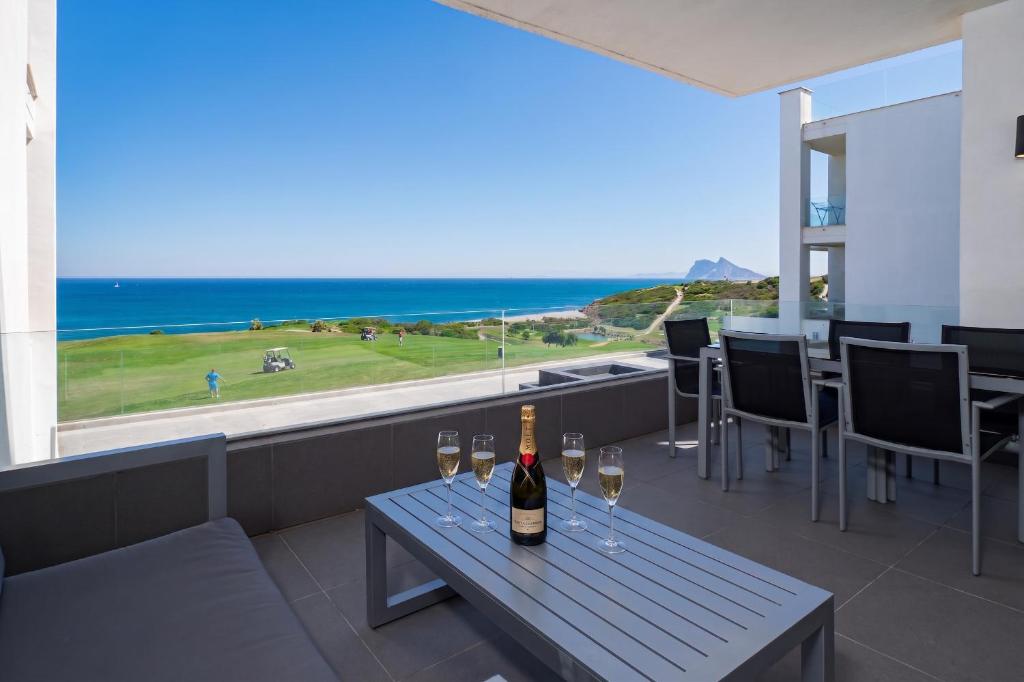 a bottle of wine sitting on a table with wine glasses at 2226-Luxury sea view apartment in La Alcaidesa