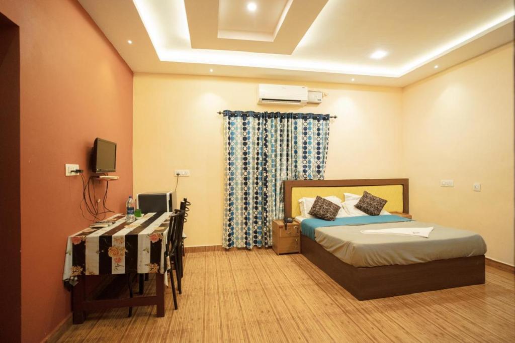 a bedroom with a bed and a television in it at Misty Slope in Ambalavayal