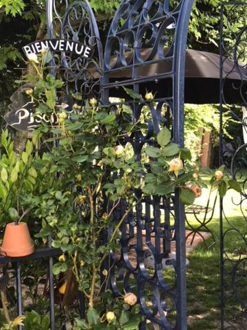 a black iron gate with a plant on it at Les Poiriers Rouges in Mauchamps