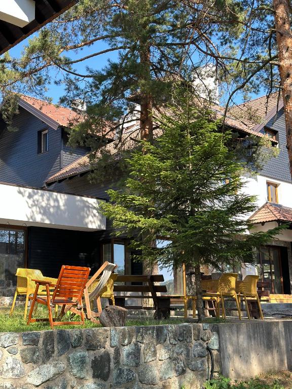 a group of chairs and a picnic table in front of a house at Vila Plamenac in Divčibare