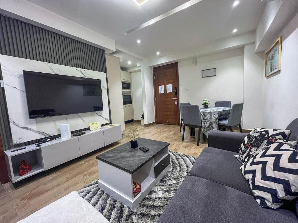 a living room with a large flat screen tv at Solaris Executive Suites Osu Pool Gym in Accra